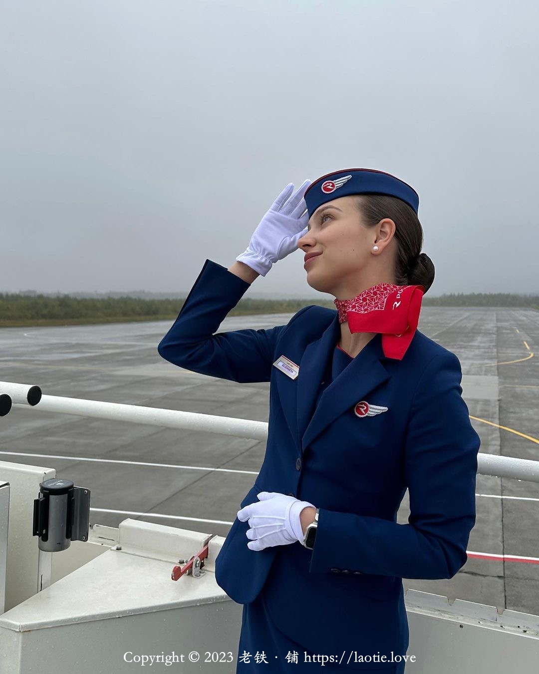 一个年轻的俄罗斯空姐在机场停机坪瞭望天空
