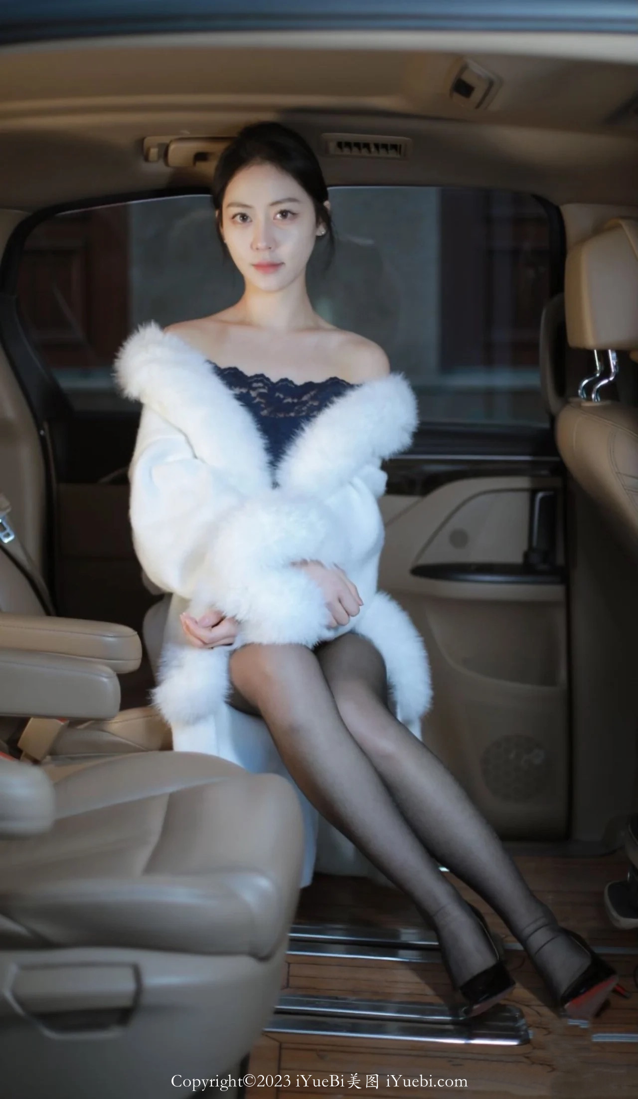 私家车后座上的白色绒毛大衣黑丝长腿美少妇