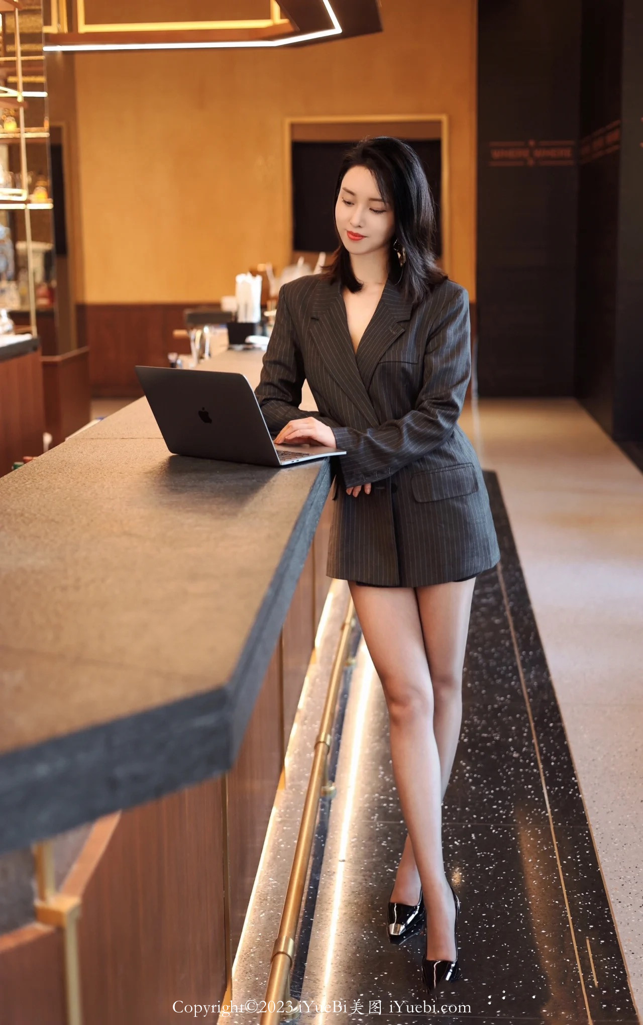 酒店吧台前正在使用笔记本电脑的大长腿服务员